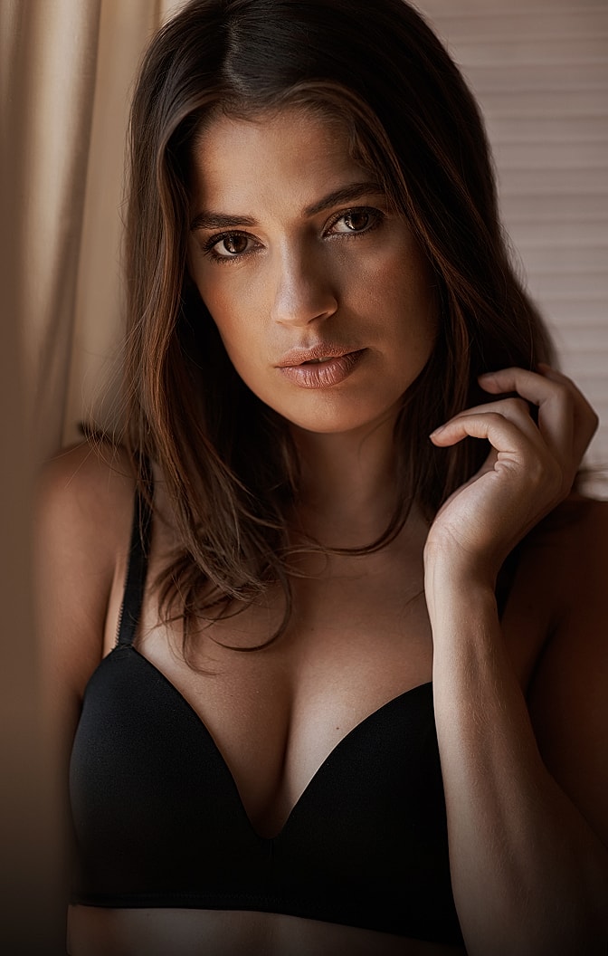 Woman in black lingerie near window.