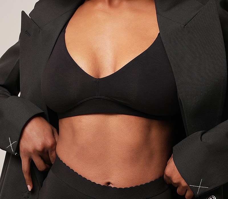 Model showcasing stylish black lingerie and blazer.
