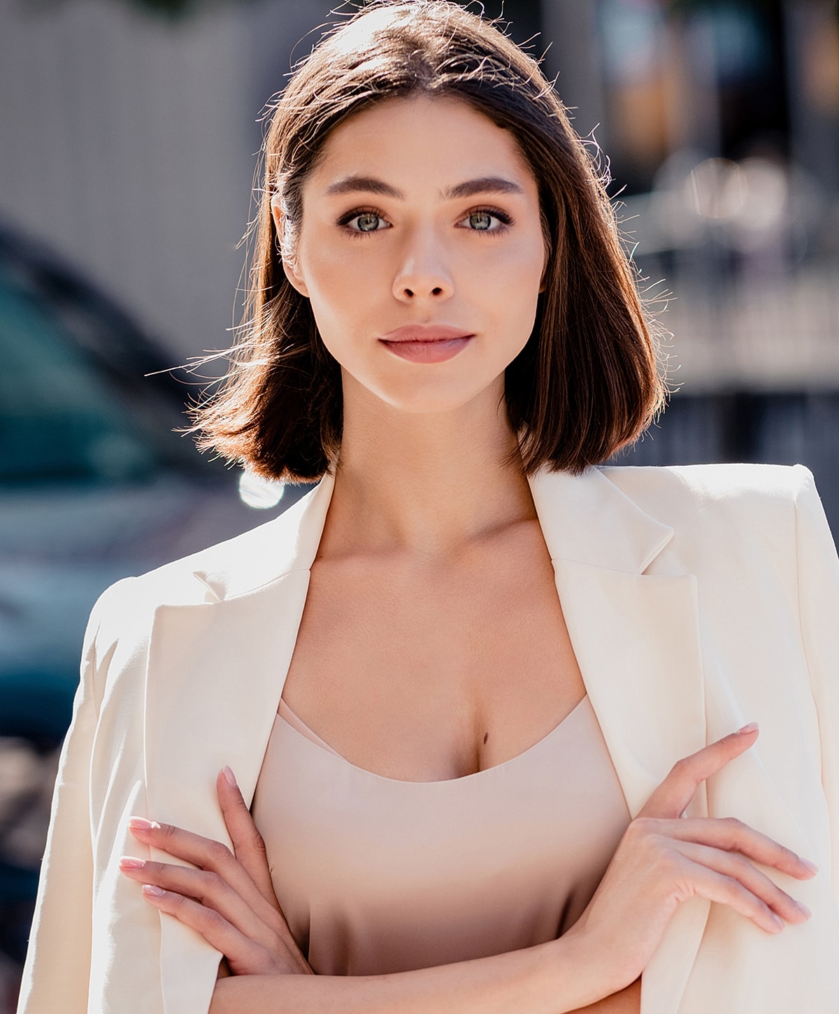 Confident woman in white blazer outdoors.