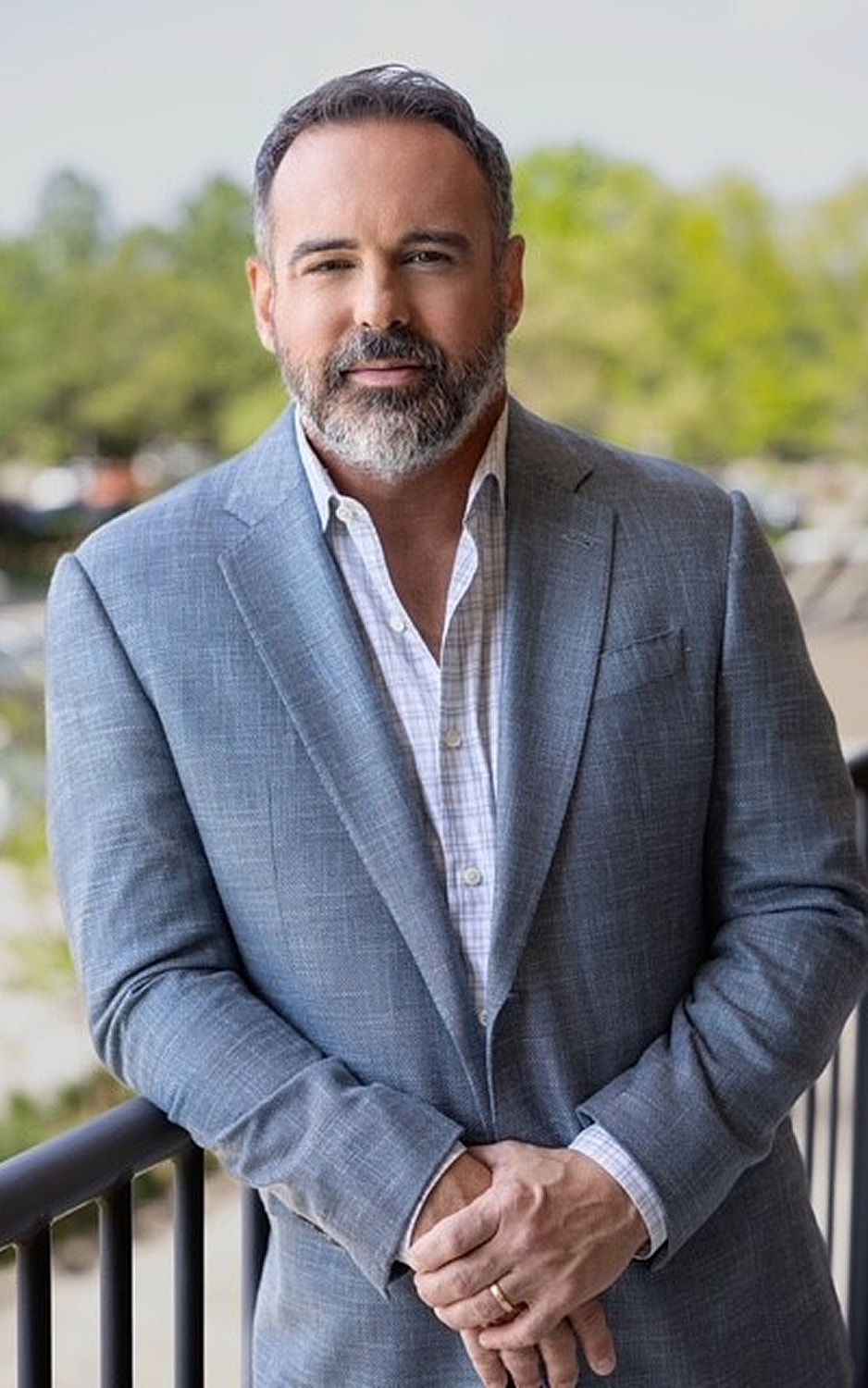 Man in gray suit standing outdoors.